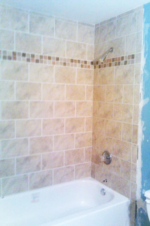 This bathroom started with a very old plastic tub and shower. All torn out. New backer board, cast iron tub, insulation, plumbing, brick pattern tile and mosaic trim was installed.